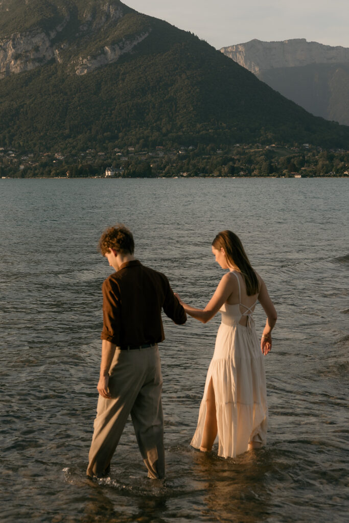 couple qui joue dans l'eau du lac face aux montagnes