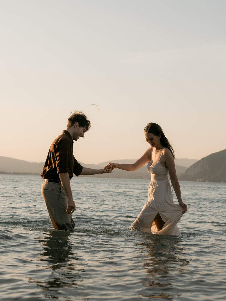 couple qui joue dans l'eau du lac face aux montagnes